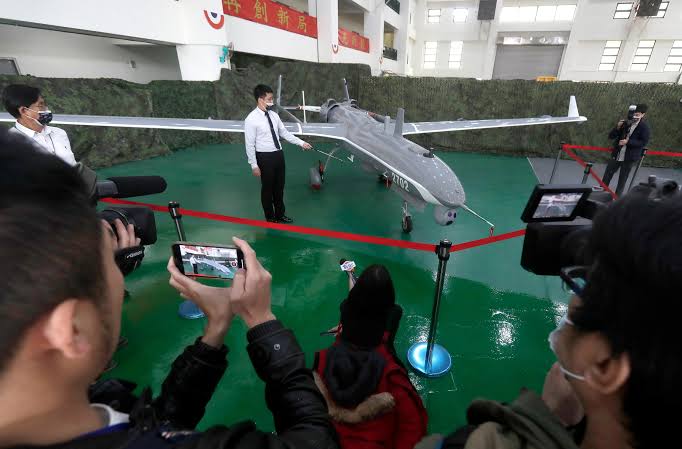 Cidadãos taiwaneses, jovens e idosos, participando de um curso de pilotagem de drones em sala de aula