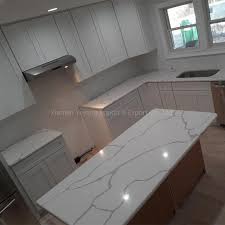 The wood finish is complemented with a lighter, but grainier wood for the flooring, while the white walls and frosted glass hanging cabinets gives this galley kitchen lighter elements. China Calacatta White Quartz Stone Slab Countertop For Kitchen Cabinets Solid Surface Counter Vanity Table Top China Artificial Stone Quartz Countertop