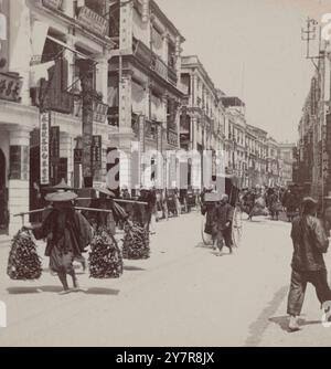 Vintage 19th century photograph: Hong Kong (China) c.1880's - shops in the Chinese quarter of the city. Road busy with traffic, pedestrians and rickshaws Stock Photo - Alamy