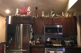 It will look cozy above the cabinets, and even better when matched up with bouquets of darling faux flowers. Christmas With Garland For Decorating Above Kitchen Cabinets