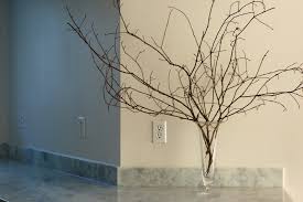 Vase with flowers standing near the window. Decorating With Branches Cozy Designed Interiors Kenya