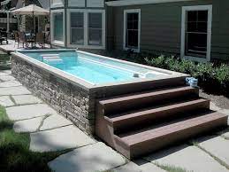 Long And Narrow Above Ground Pool With Wooden Stairs And Concrete Patio Area Endless Pool Backyard Endless Pool Pool Landscaping