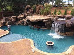 A natural pool setting creates a oasis in the midst of a busy neighborhood. Custom Pool Faux Rock Grotto 40 Slide Swimming Pools Backyard Backyard Oasis Pool Luxury Swimming Pools