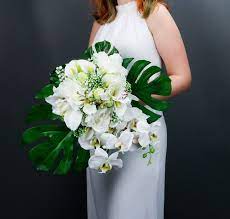 The tropical flowers are having so many colors that you will have to choose them wisely and to arrange so, when you're hiring a florist be sure that he's having the type of tropical flowers that you want for bridal hairstyles with modern and romantic accessories. Tropical Wedding Bouquet With White Orchids And Greenery Silk Etsy Tropical Wedding Bouquets Tropical Wedding White Orchids Wedding