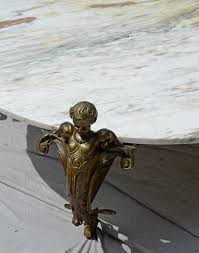 The circular glass top raised on a base of three bronze winged cherubs, france, 20th century. Sold Price Massive Brass Coffee Table With Winged Cherub Legs Square Brass Tubular Cross Section Base With Round White Marble Top 59 1 2 Diam September 2 0117 11 00 Am Edt