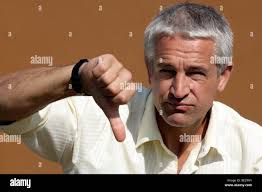 Bel homme donnant assez malheureux bored femme candy bouquet de fleurs. Les  jeunes présents avec copain agenouillé devant cadeau petite amie Photo  Stock