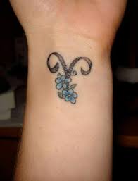 The tattoos for men are much more elaborate in comparison to that of women. Blue Flowers And Aries Tattoo On Wrist