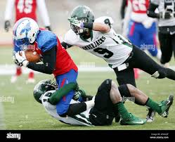 Hutchinson Community College's Jabril Soloman (81) is tackled by Dakota  College at Bottineau's Antwan Moore (15) and DeAndre Norris (9)