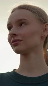 Lady in Green Top Looking Thoughtfully Under Glowing Sky with Pink Lips