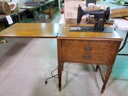 You can opt for a small model with two drawers, two cubbies and a wide tabletop for your sewing machine and materials. Kenmore Sewing Machine In Wooden Cabinet Harmeyer Auction Appraisal Co