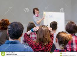 Group Of Students Listening Lecturer Staying At Flip Chart