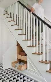 A Contemporary Foyer Staircase Features Built In Storage Fitted With Easy Access Pull Out Drawers Hidden Behin Staircase Storage Stair Storage Staircase Design