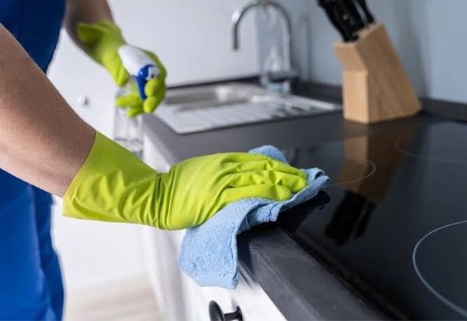 Experienced home cleaners performing detailed residential cleaning in a spacious kitchen and living room, disinfecting countertops, polishing fixtures, and organizing the space with professional equipment. The image highlights reliable residential home cleaning services, cleaning services for residential, residential cleaners near me, and residential cleaning companies delivering exceptional results with every visit.