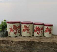 All canisters stand on decorative bases. Vintage Kitchen Canister Set Of Four Red Cream Fruit Metal Vintage Kitchen Canisters Vintage Kitchen Kitchen Canisters