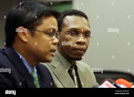 Edmon Burns listens as his attorney Gilbert Sison announces that a lawsuit  has been filed against the Maplewood, Missouri and St. Louis Police  Department in Clayton, Missouri