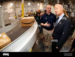 Joe Dudek, left, general manager of the Amazon fulfillment center, explains  the shipping prices to U.S. Rep. Mike Coffman, R-Colo., during a tour of  the facility Thursday, May 3, 2018, in Aurora,
