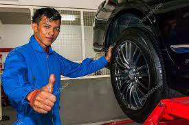 Happy young technician giving thumbs up while replacing tires Stock Photo  by &copy;twinsterphoto 111964358
