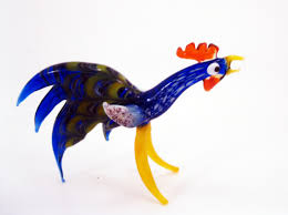 Rooster weather vane figurine on top of the roof with blue sky in the background. Glass Rooster Miniature Cock Hen Gift Blown Scu Artmosfair