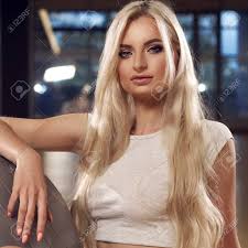 Click here for the best hair oils for blonde hair, according to editors. Half Body Portrait Of Beautiful Woman With Long Blonde Hair And Blue Eyes Dressed In White