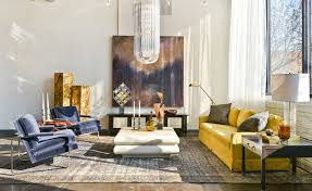 Modern living room with a grey sofa, yellow pillows, a table, an artwork and dark floors. How To Design With And Around A Yellow Living Room Sofa