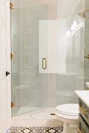A Seamless Glass Door Accented With Brushed Gold Hardware Opens To A Walk In Shower Boasting Large Gray Sub Shower Door Hardware Shower Doors Shower Renovation