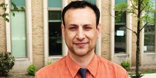 A faculty member at the University of Kufa receives a peer reviewer  certificate from an international Journal