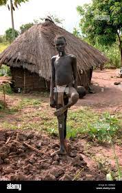 Sudanese teenage boy standing by a hut in a village in Southern Sudan,  African Stock Photo - Alamy