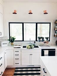 Black And White Farmhouse Kitchen Modern Farmhouse Kitchen Black Fixtures White Cabinets Window Over Sink Copper Sconces Plants Chrome Faucet Home Modern Farmhouse Kitchens Black Kitchens