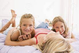 Frau Liegt Im Bett Mit Zwei Jungen Madchen Lachelt Lizenzfreie Fotos Bilder Und Stock Fotografie Image 3600814