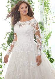 This gown with chapel train is styled in subtly beaded embroidered lace appliques on tulle. Patience Plus Size Wedding Dress Morilee