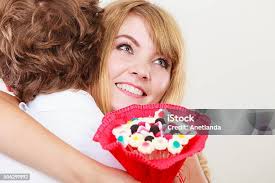 Couple With Candy Bunch Flowers Hugging Love Stock Photo