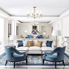 A Predominantly White Room With Blue Accent Chairs A Striking Blue And White Rug And Gold Accents Luxury Living Room Farm House Living Room Gold Living Room
