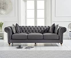 Classic chesterfield with updated silvery gray velvet cover features hand applied chrome nailheads and jewel tufting on inside back,throw pillow and top of arms. Carrara Chesterfield Velvet 3 Seater Sofa