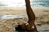 Frau macht Yoga am Strand, nackt