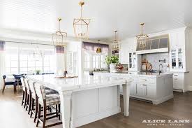 This is a light and luxurious space. Two Kitchen Islands Unified With Brass Lanterns Transitional Kitchen