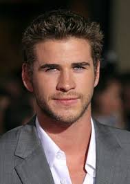 I lean against the pine tree with my axe set beside me, and my pad and pencil in hand. Liam Hemsworth Hunger Games Reel Life With Jane