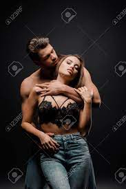 Muscular Man Hugging Seductive Girl With Big Breast On Black Stock Photo,  Picture and Royalty Free Image. Image 141256962.