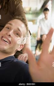 Allegra donna sorridente e spingendo la sedia di paura fidanzato Foto stock 