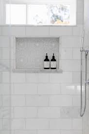 We would 100% install marble tile again in our bathroom. White And Gray Mosaic Tiles Accent A Shower Niche Surrounded By Calcutta Marble Subway Tiles And Positio Shower Niche Tile Shower Niche Bathroom Remodel Shower