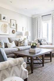 Light Gray Sofa With White And Gray Pillows Against A Wall Showcasing A Staggered Art Gallery Living Room Grey Grey Sofa Living Room Grey Furniture Living Room