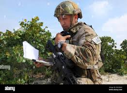 U.S. Air Force Senior Airman Connor Shoemaker, a loadmaster assigned to the  816th Expeditionary Airlift Squadron, helps push a container onto a  K-loader from the aircraft at Bagram Airfield, Jan. 25, 2018.
