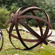 An Orb To Ornament The Garden Gardenista Metal Garden Art Garden Art Garden Spheres