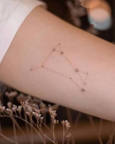 Fine line constellation tattoo on the inner arm.