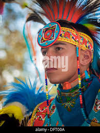 Young Native American dancer dancing in regalia at a Pow Wow where  traditions, culture, dancing, drumming, and singing are