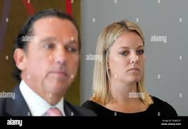 Dr. Hillary Cauthen, right, a former consulting psychologist for the San  Antonio Spurs, listens as her attorney Tony Buzbee speaks during a press  conference, Thursday, Nov. 3, 2022, in Houston. Cauthen has