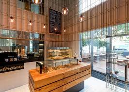 A Cage Like Grid Of Brass Poles Surrounds The Upper Section Of This Double Height Patisserie In Shenzhe Wine Shop Interior Retail Interior Shop Interior Design