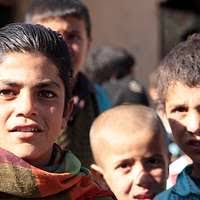 A child carries shovels and rakes along a road in Torkhel
