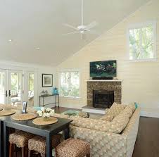 Sophisticated living room features a sloped ceiling accented with rustic wood beams placed over a gray couch with chaise lounge facing a gray cowhide bench doubling as a coffee table atop a sky blue rug. Living Room With Wood Slants To The Slanted Ceiling Maritim Wohnbereich Charleston Von Watts Builders Houzz