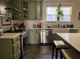 The green kitchens are recognized around the globe for their exotic look and stylish allure. American Foursquare Kitchen Sage Green Cabinets White Subway Tile Dark Grout Wood Tile Floor Qua Kitchen Remodel Wood Floor Kitchen Green Kitchen Cabinets