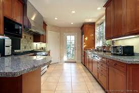 Galley kitchen design features a few common components, and chief among them is the traditional layout for a galley kitchen—these kitchen designs generally feature a narrow passage situated between two parallel walls. Traditional Medium Wood Cherry Kitchen Cabinets 56 Kitchen Design Ideas Org Bkm Gran Galley Kitchen Layout Galley Kitchen Design Small Kitchen Design Photos